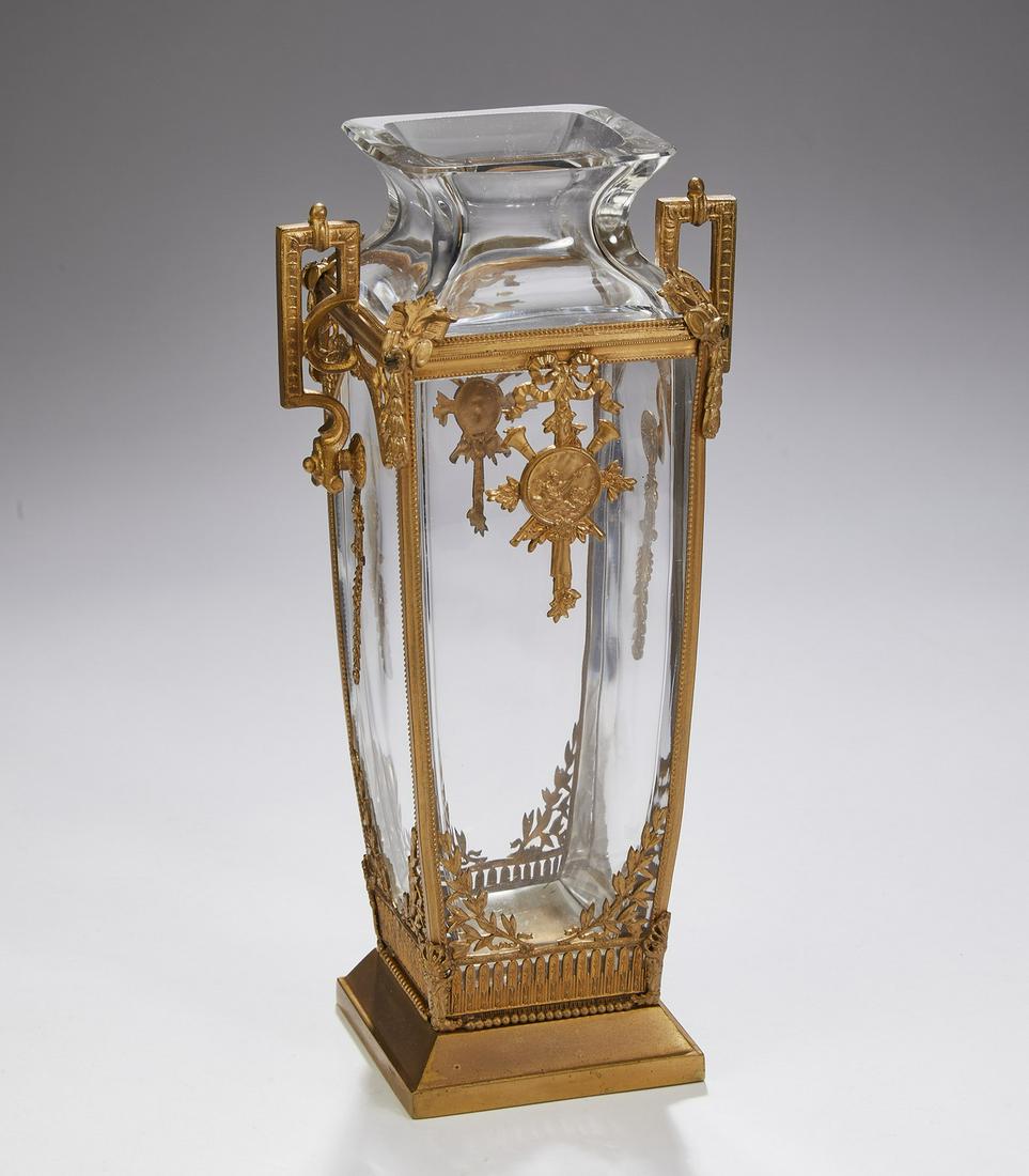 Louis XVI style crystal and gilt brass vase: Crystal and gilt brass vase in the Louis XVI taste, of elongated square amphora form, having square brass handles on an armature centering a circle with a putto playing a lute, against a cartouche com