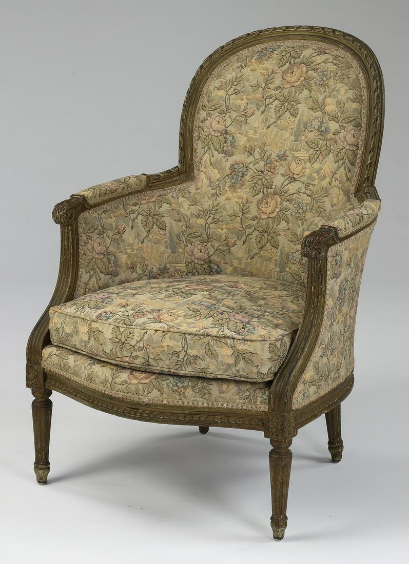 Louis XVI style carved and paint decorated bergere: Carved and paint decorated bergere in the Louis XVI taste, early 20th century, having an arched back flowing into partially upholstered arms ending in scroll terminals, flanking a drop-in seat cushion