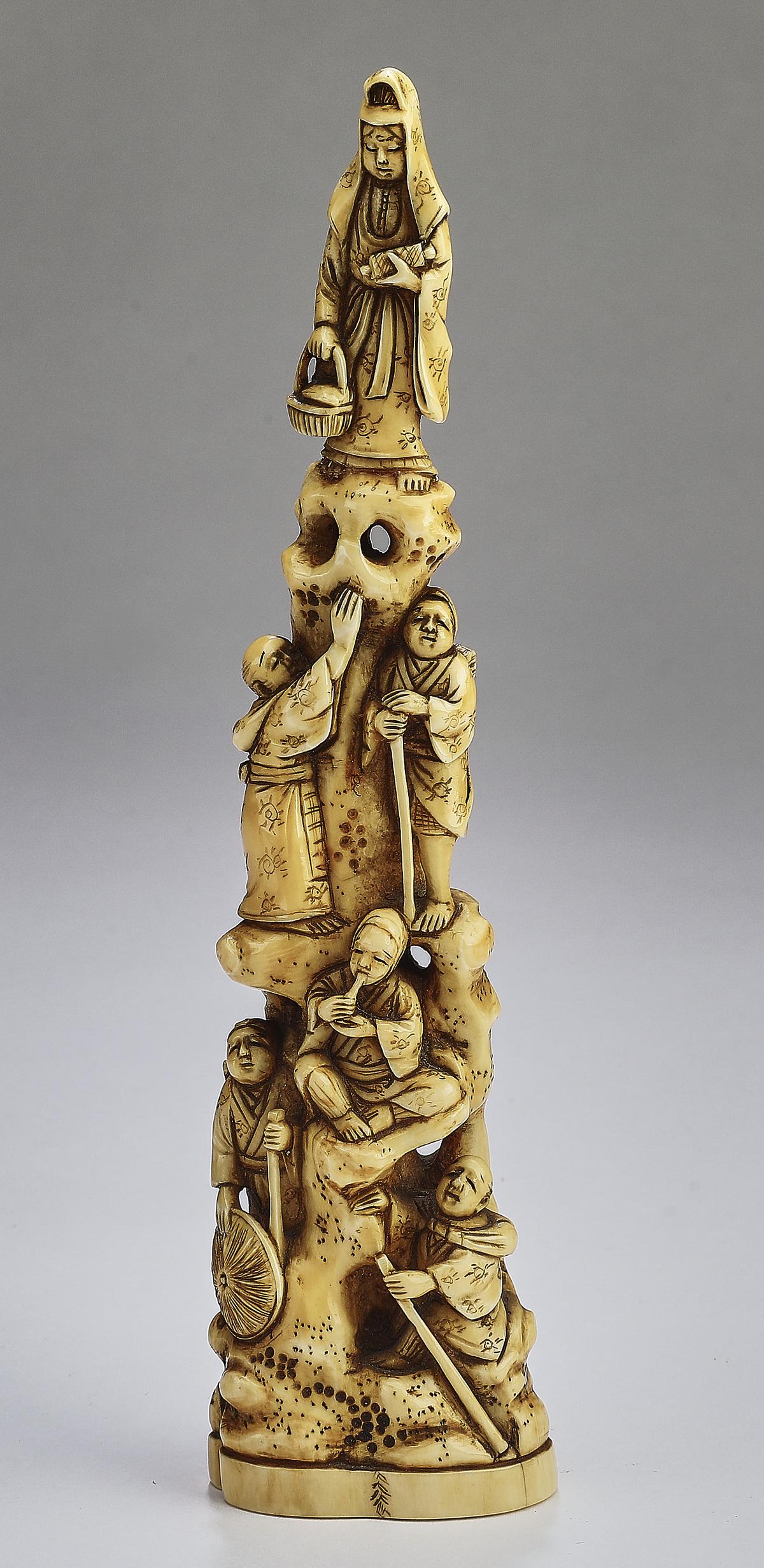 Chinese carved bone figure of Quan Yin, signed: Chinese carved bone figure, depicting Quan Yin standing on rockwork with monks, scholars, and attendants below, signed underneath, 7.5"h x 2"w x 1"d.