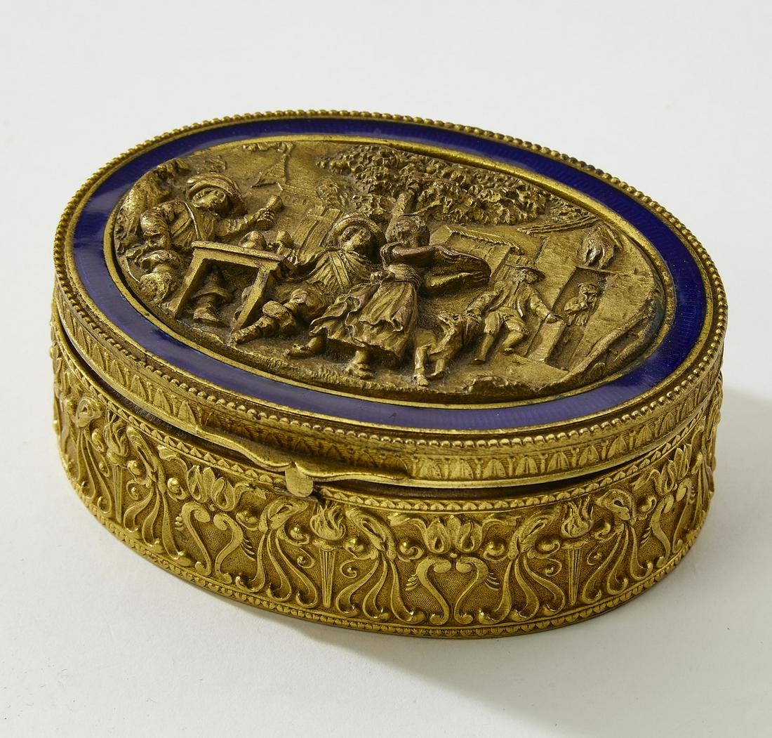 Enameled brass dresser box with a genre scene, 4"w: Enameled brass dresser box, of ovoid form, the lid with a cobalt border centering a genre scene of a tavern courtyard, the sides decorated with torches and acanthus scrollwork, opening to a velvet lin