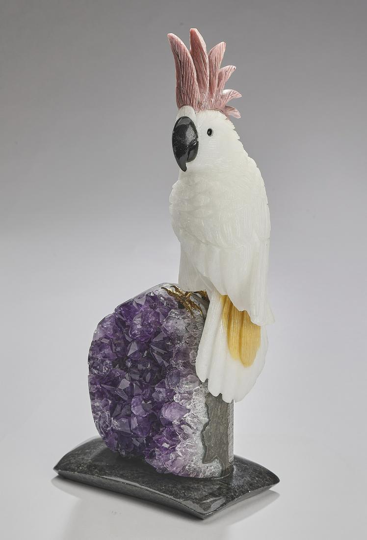 Carved Brazilian mineral specimen cockatoo: Carved mineral specimen cockatoo, executed in calcite, obsidian, and rhodecrosite, the cockatoo depicted perched on an amethyst specimen, resting on a black dolomite base, attributed to Amsterdam Saue