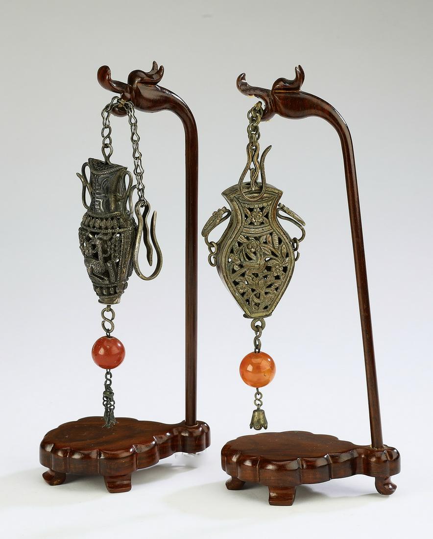 (2) Chinese silver metal pendants on dragon stands: Two Chinese silver metal pendants, the first of urn form, having pierced decoration of a spotted deer under a pine tree, 4.5"h x 1.25"w; the second of vasiform, decorated with a mouse and grapes, 4.5"