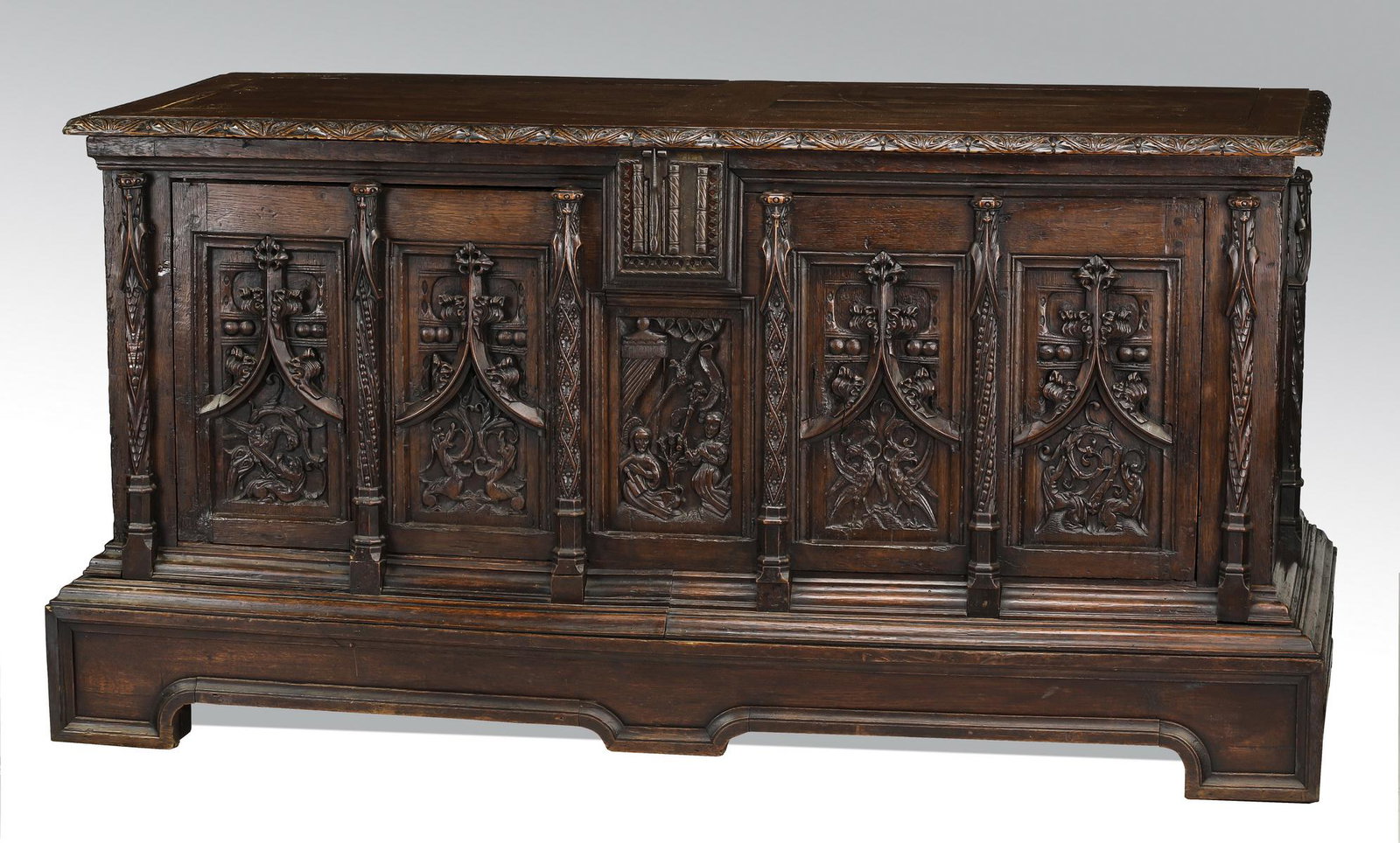 Oversized French Gothic Revival carved oak cassone: Oversized French Gothic Revival carved oak cassone, late 19th century, having a hinged top with carved edges over a conforming case fitted with two tracery doors opening to adjustable shelves, the who
