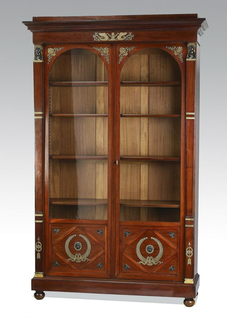 19th c. French Empire style mahogany bookcase: Late 19th to early 20th century French Empire style mahogany bookcase, having a molded cornice rising on the bronze-mounted frieze depicting swans, surmounting the partially glazed arched doors with b