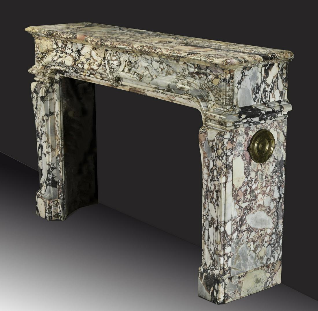 19th c. Italian carved breccia marble mantel: 19th century Italian rouge and cream breccia marble mantel in the Neoclassical taste, having a rectangular top fronted by a demi-lune center, above a frieze centering a Rococo inspired cabochon, risin