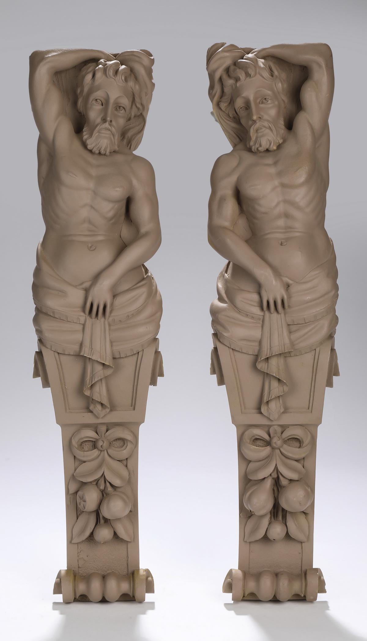 (2) Unfinished cast composition classical pilasters: Pair of unfinished cast composition male term figure pilasters, each depicting a classical male nude with one arm over his head and draped at the waist, above a relief molded swag of fruit, and termin