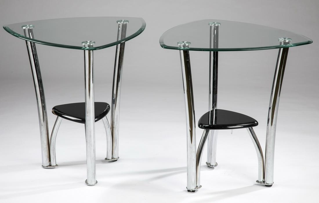 (2) Contemporary glass & chrome side tables, 25"h: Two late 20th century glass and chrome side tables, in the Moderne style, the triangular glass tops over an ebonized wood shelf, with the supports joining the three legs, each 25"h x 24"w.