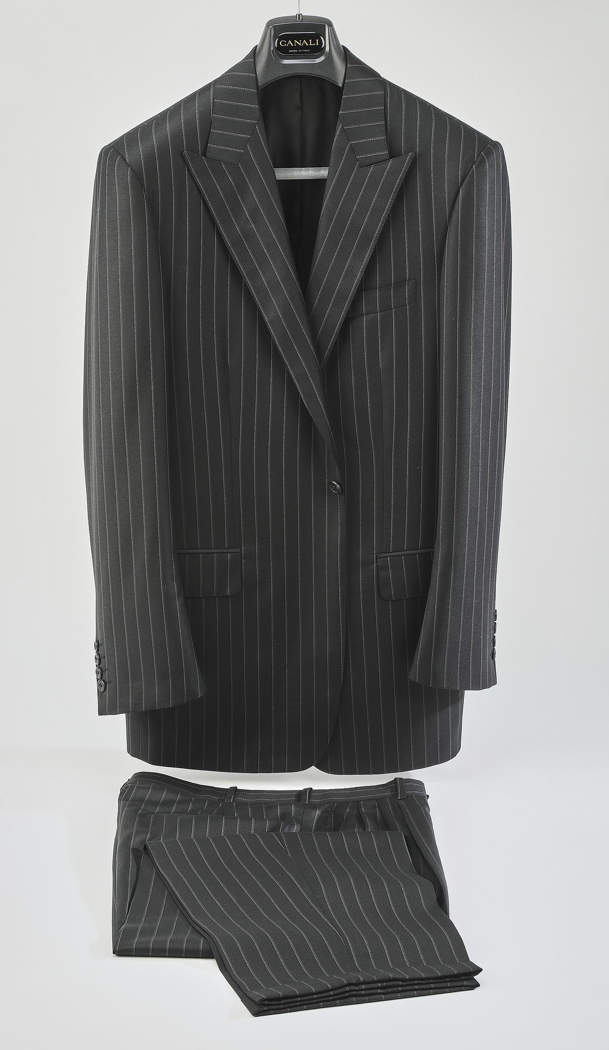 Two piece single breasted chalk stripe suit: Two piece single breasted suit of charcoal grey chalk stripe wool, having a single button, with two back (side) vents, label 'Tailor Shop Collezione by Daniel Motorca,' 34"l x 20"w at the shoulder, sl