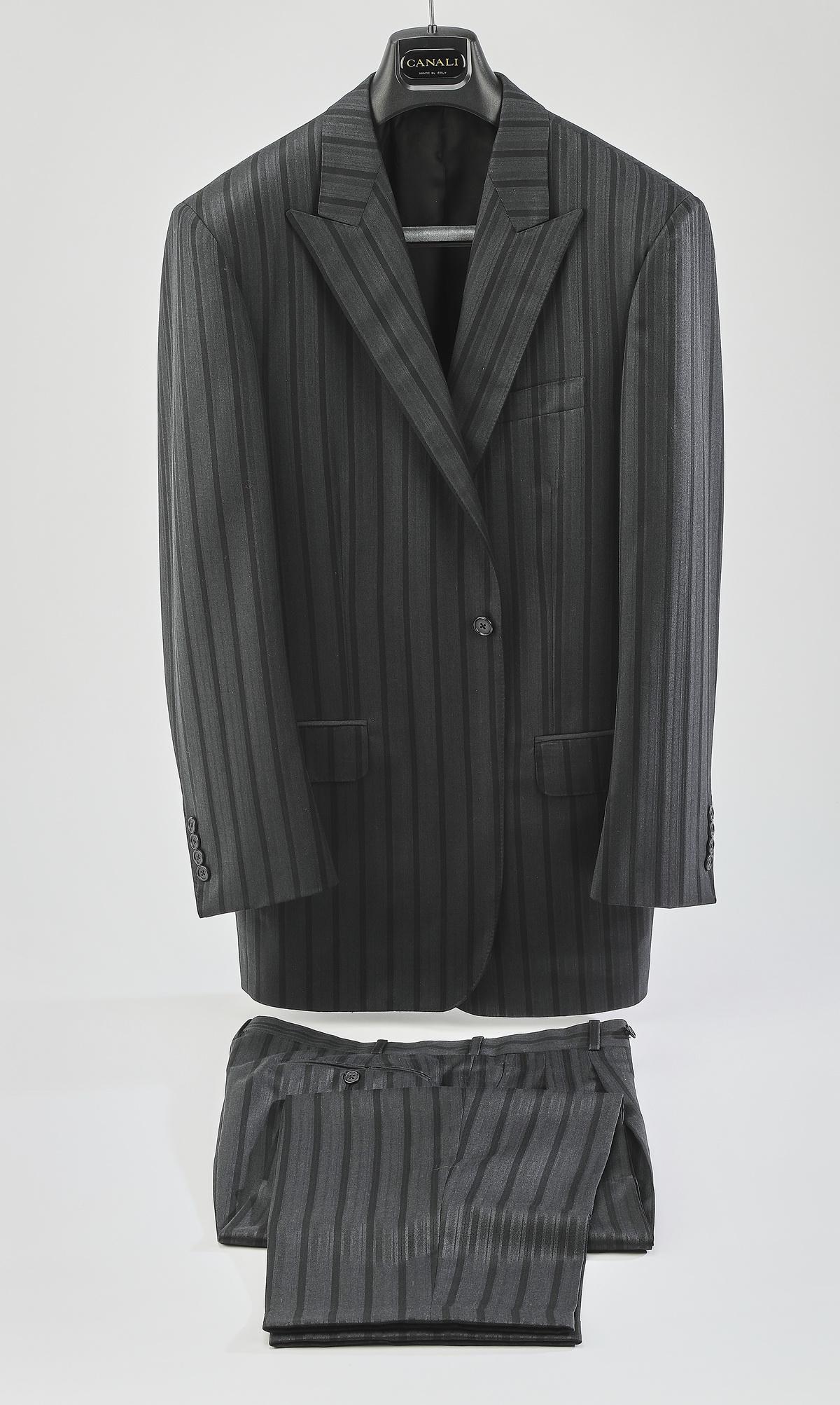 Two piece single breasted striped suit: Two piece single breasted suit of wool blend in a charcoal grey with blue variegated stripes, having a single button, with two back (side) vents, label 'Tailor Shop Collezione by Daniel Motorca,' 33.5