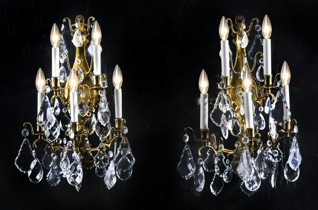 (2) Gilt bronze and crystal 5-arm wall sconces, 22"h: Pair of gilt bronze and crystal 5-arm wall sconces, each having a baluster form backplate issuing five scrolling arms hung with French drops and crystal swags, 22"h x 14"w x 9"d.