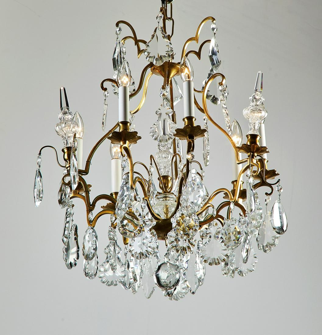 Bronze and crystal 6-light chandelier, 24"h: Mid 20th century bronze and crystal six-light chandelier in the Louis XV taste, having a cage centering a crystal obelisk issuing nine arms interspaced with three crystal obelisks and scalloped bronze