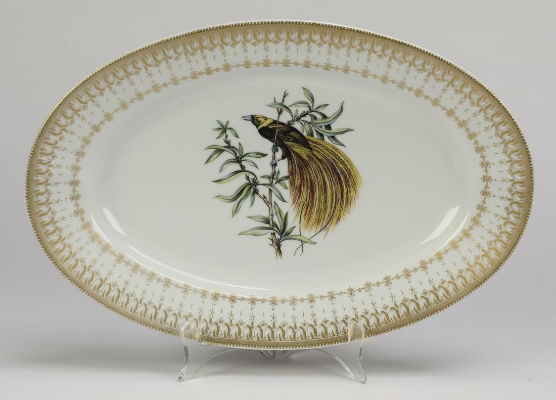 Mottahedeh hand painted 'Bird of Paradise' platter: Mottahedeh hand painted porcelain oval platter in the 'Bird of Paradise' design, centering a brilliantly plumed bird perched on a branch, framed with an elaborate gilt band, 2"h x 15.5"l x 10.25"w.