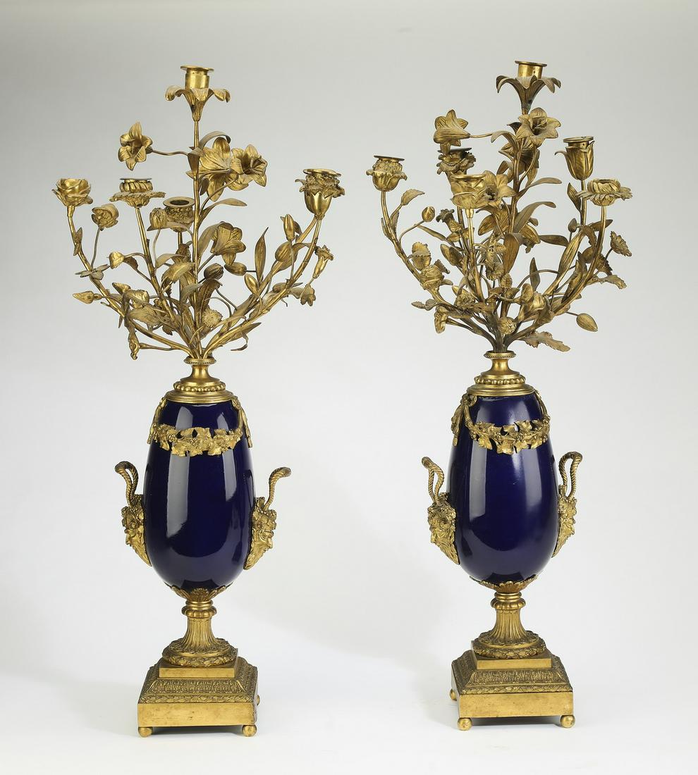 (2) Early 20th c. French marble and gilt candelabras: Pair of early 20th century French marble candelabras, having (6) gilt metal lights held aloft by naturalistic arms in the forms of various flowers, rising on the vasiform body with gilt mounted faun m