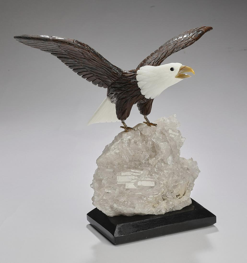 Carved mineral specimen American bald eagle: Carved mineral specimen bald eagle, executed in tiger's eye, calcite, and jasper, depicted with wings unfurled, perched on a white quartz specimen resting on a wooden base, 10"h x 11.5"w x 5.5"d.