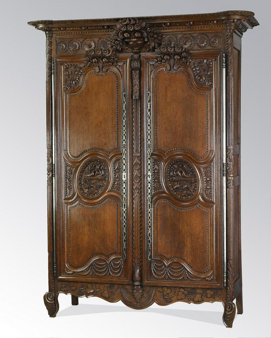 Late 18th c. French hand carved oak armoire: Late 18th century French hand carved oak armoire, having a molded cornice and pierce-carved floral arrangement medallion above a carved rosette frieze, and raised and molded doors relief carved with f