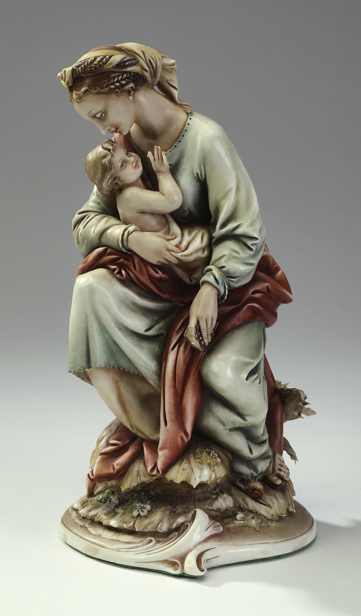 Antonio Borsato porcelain, 'Madonna and Child': Antonio Borsato Italian porcelain figural grouping, 'Madonna and Child' depicting the Virgin with a red drape holding the Christ child on her lap, the whole resting on a naturalistic signed base, 10.5