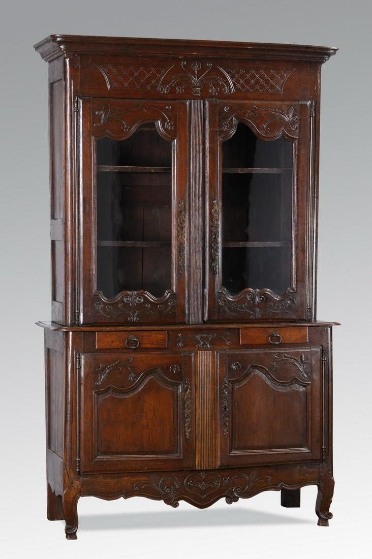 18th c. French carved oak buffet: 18th century French carved oak buffet à deux corps, the rectangular top surmounting a foliate and basket decorated frieze above two cartouche-form glass panel doors, opening to reveal two shelves ove