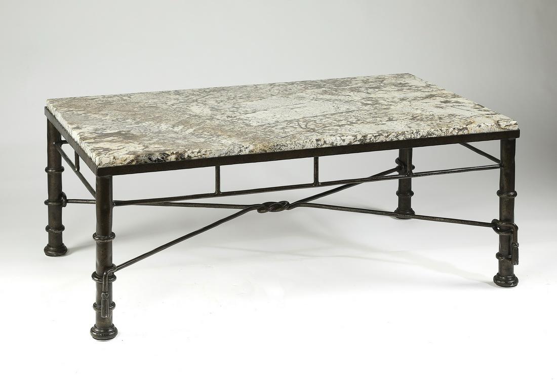 Granite and patinated iron coffee table: Granite and patinated iron coffee table in the Moderne taste, having a coffee, cream, and slate grey striated granite top, surmounting a wrought iron base with an X-shaped stretcher, 20"h x 50"l x 31"