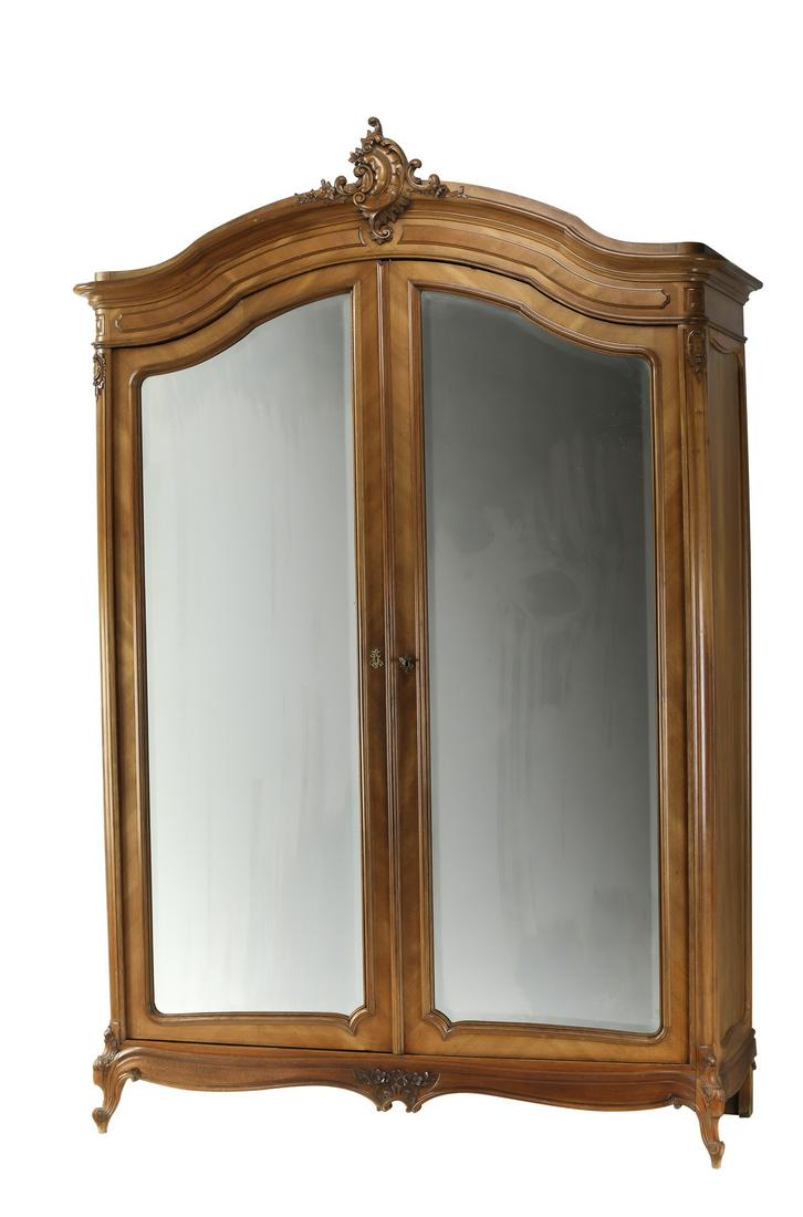 19th c. French Rococo Revival walnut mirrored armoire: French Rococo Revival walnut armoire, 19th century, having a carved rocaille finial above an arched crest and wide frieze, surmounting two arched doors with beveled mirrors, opening to four shelves, a