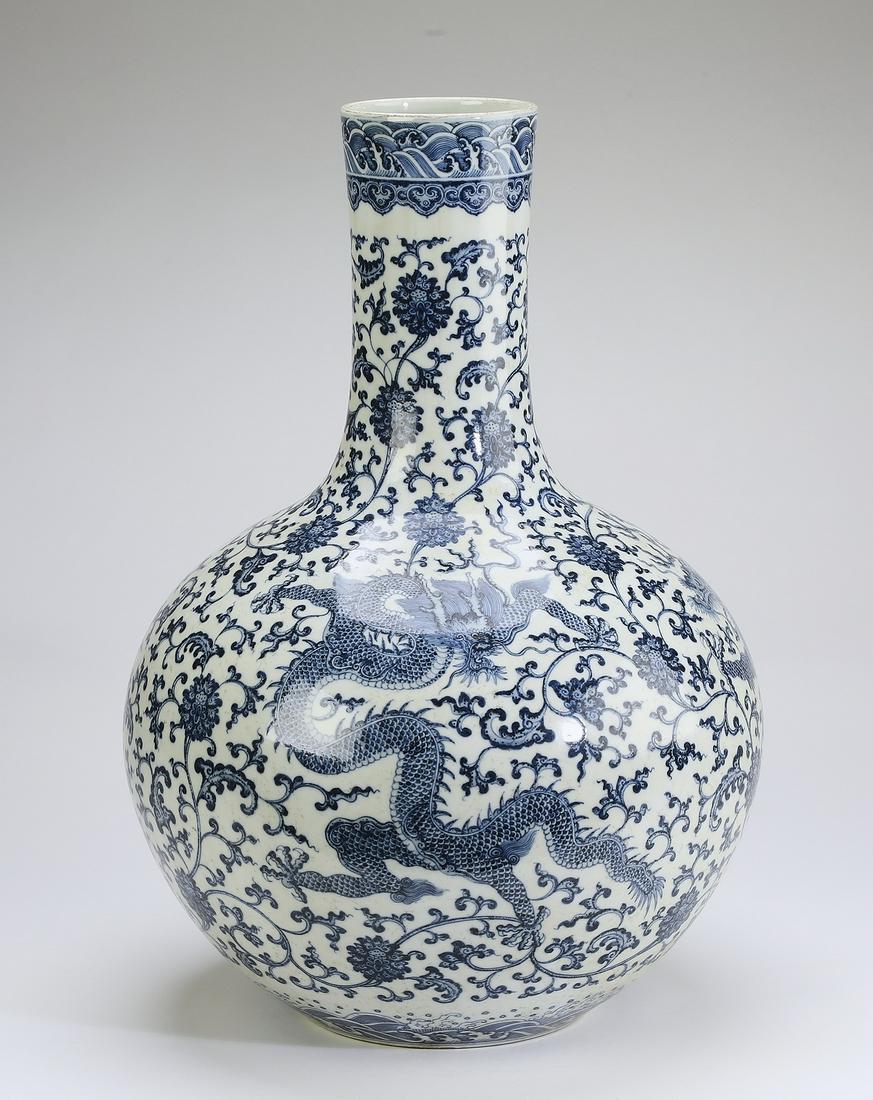 Chinese blue and white dragon vase, Qianlong mark: Chinese blue and white dragon bottle vase, the stick neck having a band of waves above a ruyi band, the body decorated with writhing five clawed dragons amidst heavenly flames and lotus scrollwork, th