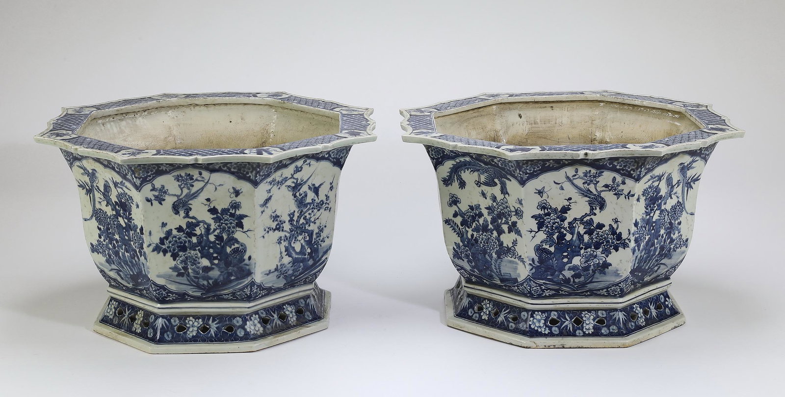 (2) Chinese blue and white paneled jardinieres: Pair of Chinese blue and white paneled jardinieres, each having a flattened, barbed, petal rim decorated with reserves depicting Buddhist treasures on a leiwen ground, the body having huaniao hua scen