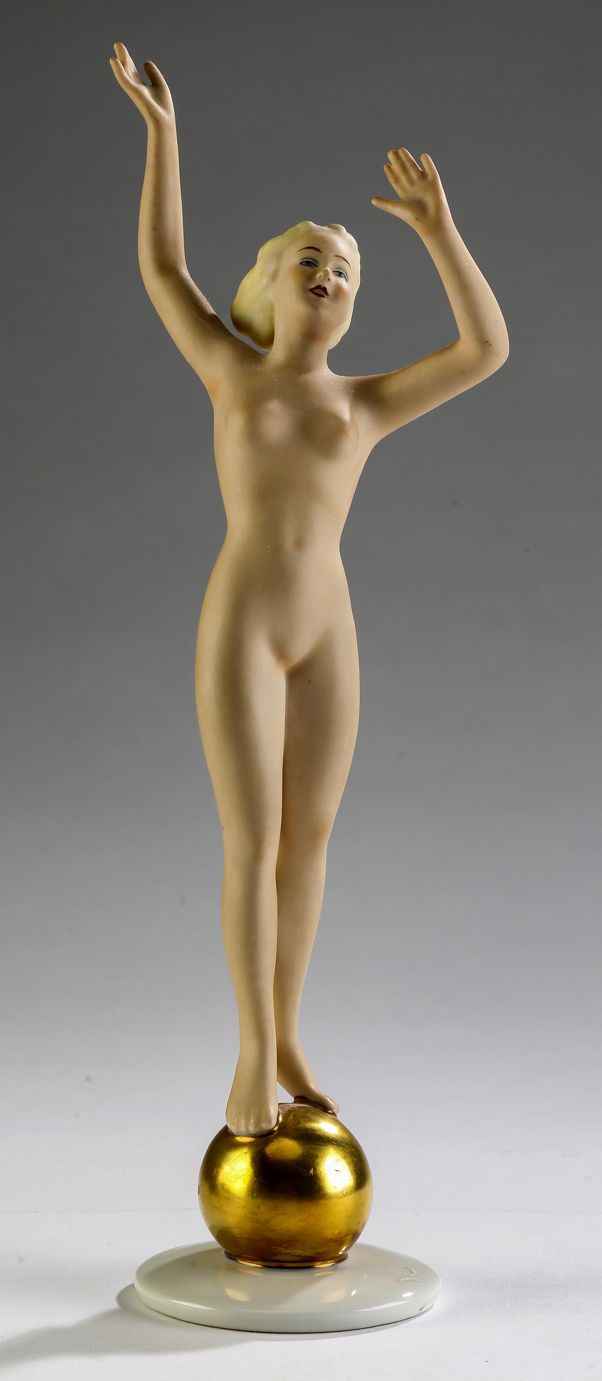 German Art Deco porcelain nude, circa 1930, 10"h: German Art Deco porcelain nude, circa 1930, the woman standing with outstretched arms balancing on a gilt ball, the whole resting on a circular base, marked Wallendorf Porcelain, Germany, 10"h x 3"dia