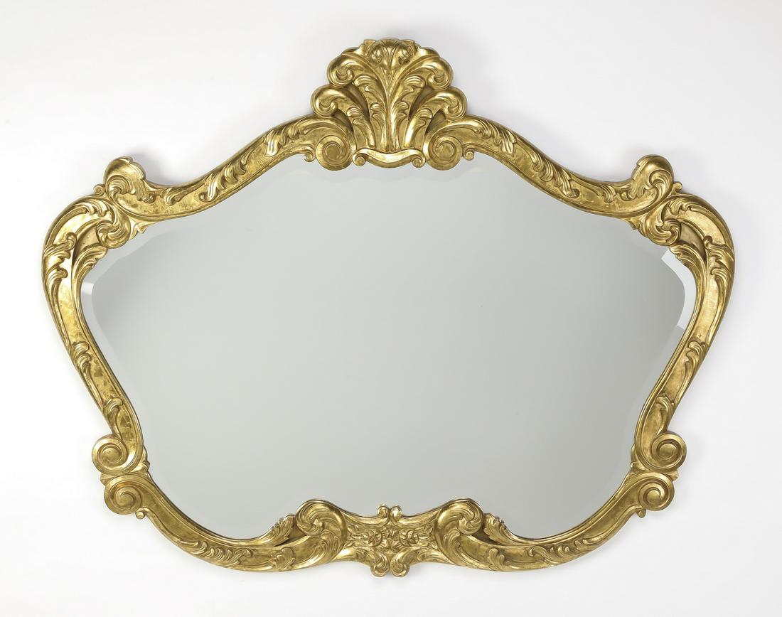 Rococo inspired gilt cartouche-form beveled mirror: Rococo inspired gilt wood cartouche-form wall mirror, the frame centering a feather crest, flanked by acanthus 'S' scrolls, surrounding a beveled mirror, 46.5"h x 56"w x 1.5"d