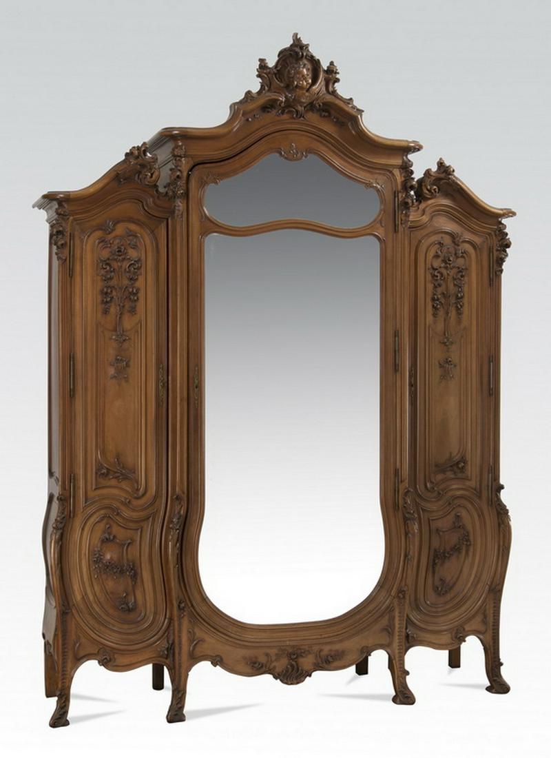 19th c. French Rococo Revival walnut armoire, 114"h: French Rococo Revival walnut armoire, circa 1870, having a rocaille crest centering a high relief cherub bust, surmounting a scrolling crest accented with carved roses and floral sprays above three do