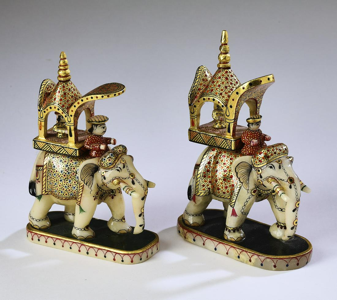 (2) Indian carved alabaster elephants w/ riders, 5.5": Pair of Indian polychrome enamel, parcel gilt, and carved alabaster sculptures, depicting elephants with mahouts (riders) and elaborate houdahs (canopied seats) with passengers, each embellished with 