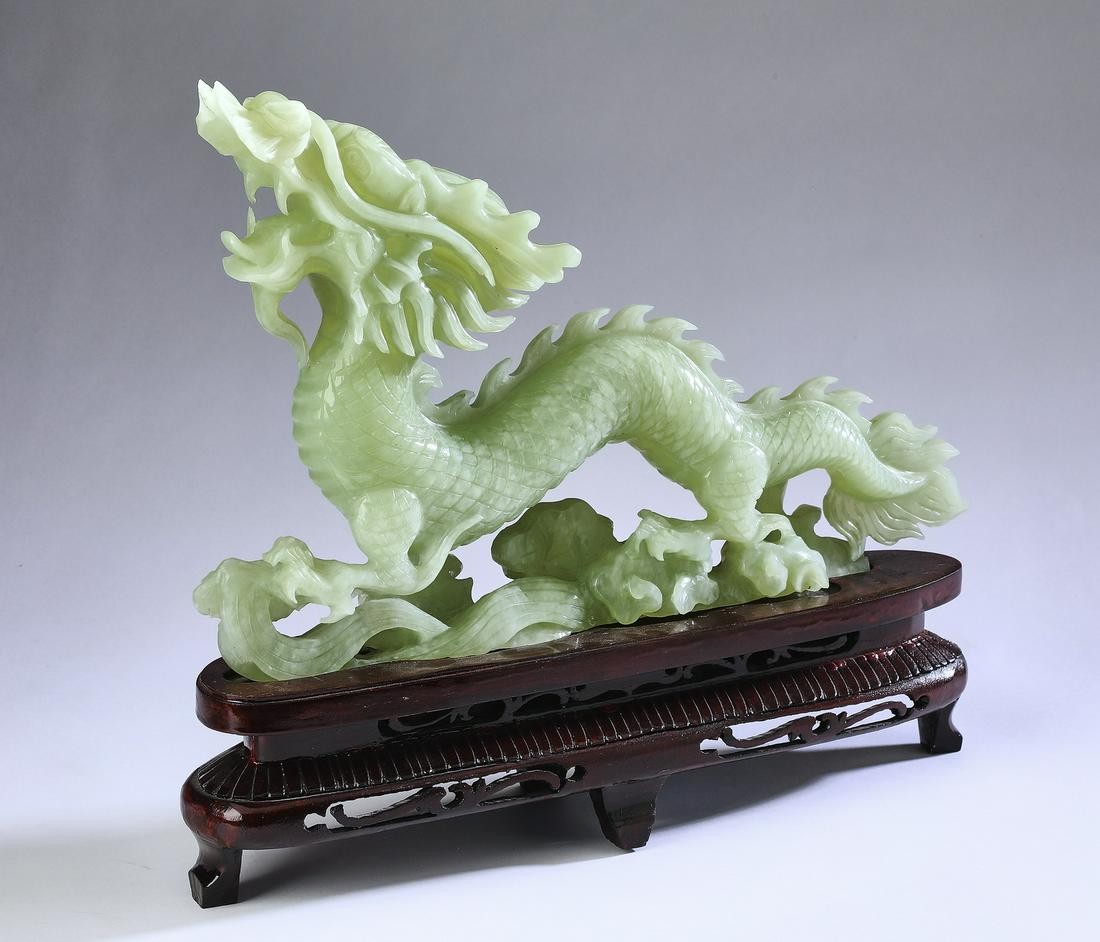 Chinese celadon jade writhing dragon on stand, 12"h: Chinese carved celadon jade writhing dragon statue, the dragon having whiskers and gliding through lapping waves, the whole resting on a custom wooden base, dragon 9"h x 14"l x 3"w; with base, 12"h x 