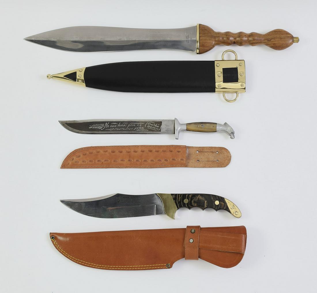 (3) Knives including a Muela Spanish bowie knife: Group of three edged weapons, comprising a Muela Spanish steel bowie knife with a wooden handle and leather sheath, 12"l (blade 7"l); a Mexican knife with a Spanish inscription on the blade, a bird fo