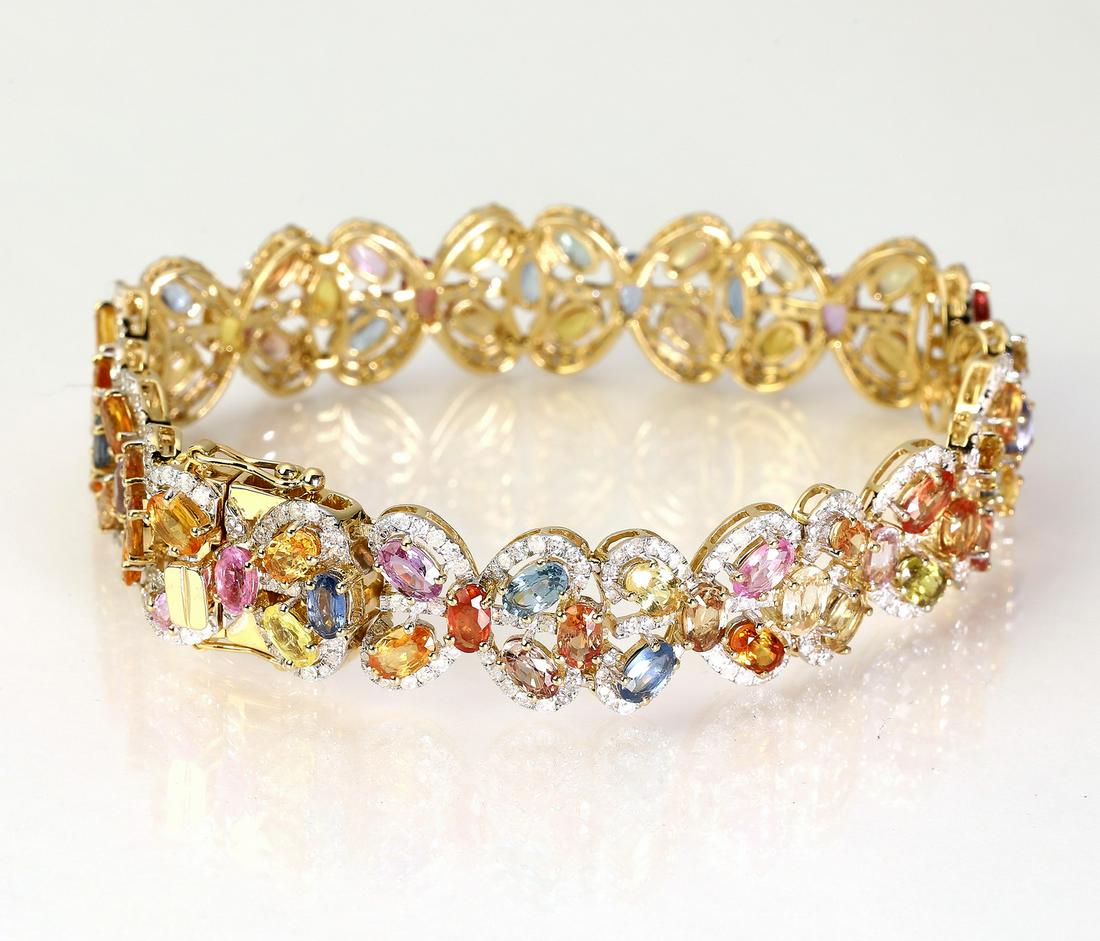 Multi-color sapphire, diamond, and 14k bracelet: Multi-color sapphire, diamond, and 14k yellow gold bracelet, having (72) oval cut 5 x 3mm fancy sapphires in yellow, pink, light blue, and orange, weighing 21.17ctw; framed by 3.51ctw of round brillia