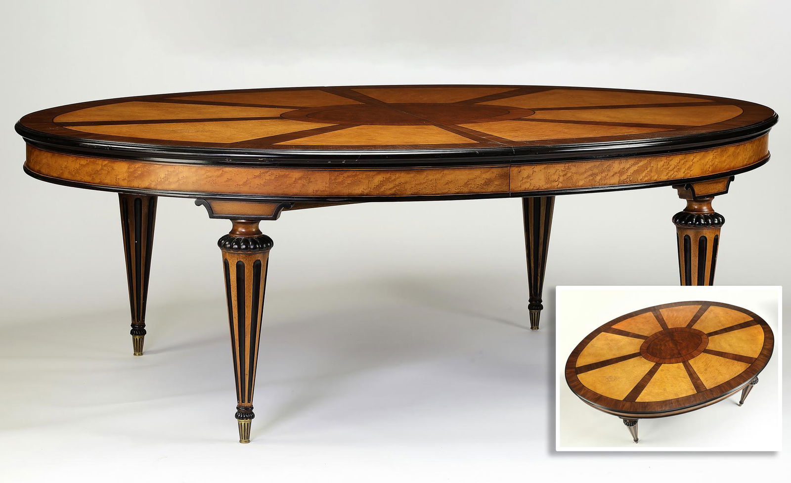 Oval dining table w/ exotic inlays and two leaves: Oval dining table in the William IV taste, executed in bird's eye maple, mahogany, and rosewood, with ebonized trim, the top having rosewood rays extending from an oval center medallion to a band at t
