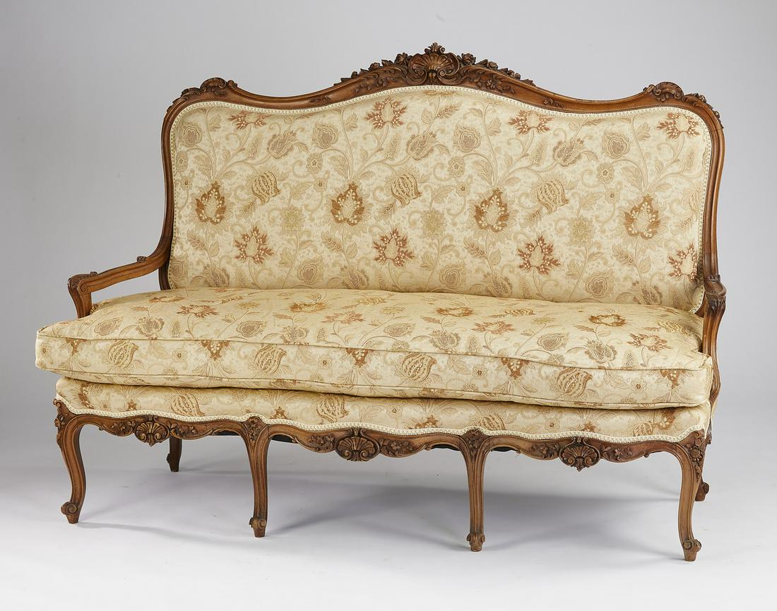 19th c. French Louis XV style carved walnut settee: Louis XV style walnut settee, late 19th or early 20th century, having a serpentine carved crest rail centering a shell flanked by floral elements and acanthus carving, surmounting an upholstered back 