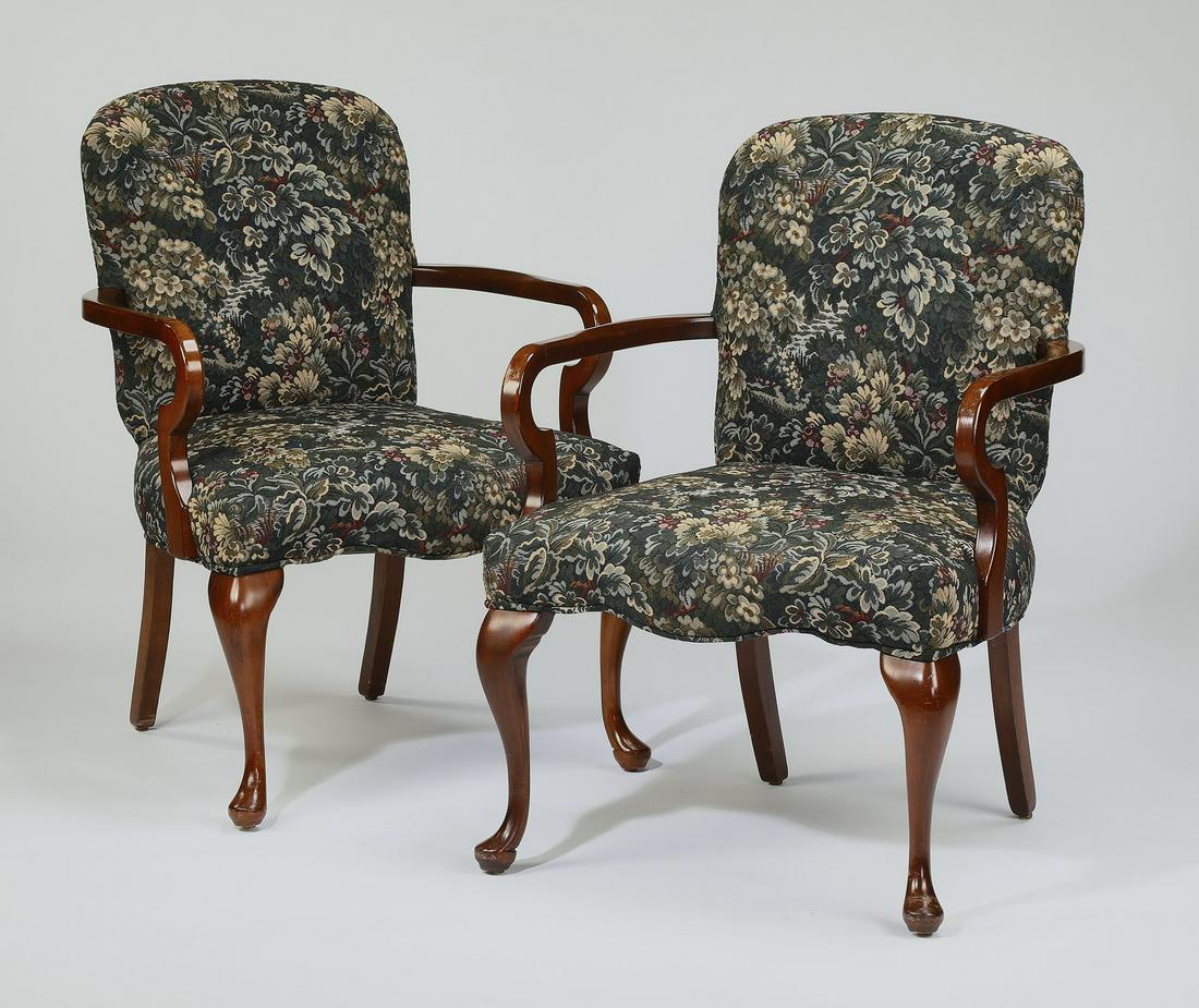 (2) Queen Anne style upholstered armchairs: Queen Anne style upholstered armchairs, having a square back with rounded corners, gooseneck arms, and serpentine seat, the whole rising on cabriole legs terminating to pad feet, 34.25"h x 24"w x 26"d