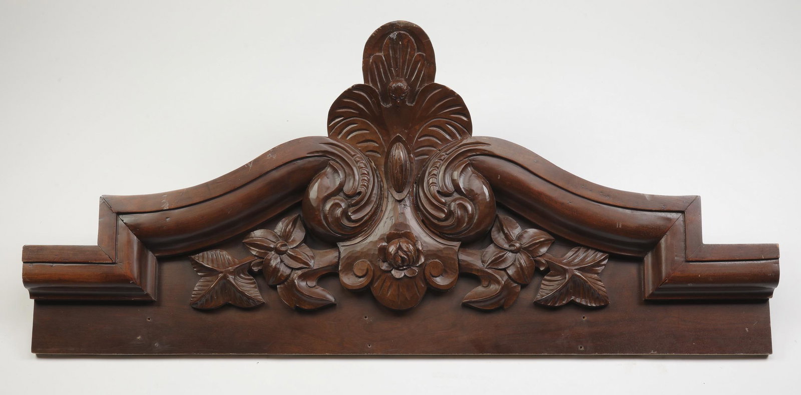 Early 20th c. carved architectural element, 56"w: Late 19th or early 20th century carved architectural element, having an arched cornice with central carved foliate crest, flanked in scrollwork, and terminating in a carved foliate vine, 25"h x 56"w x