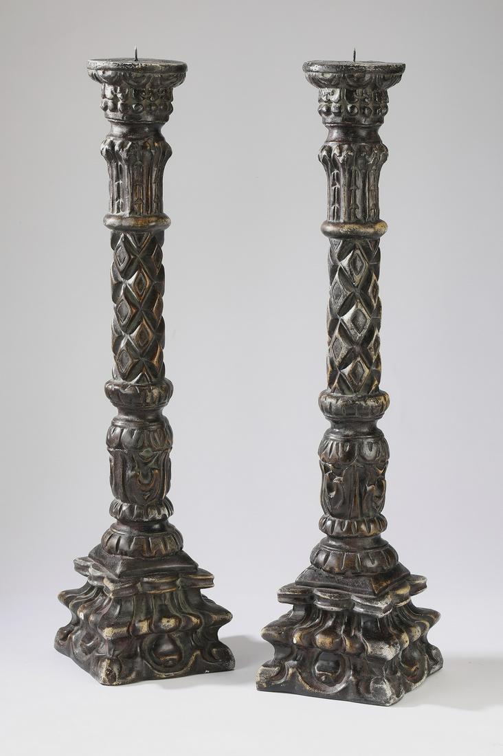 (2) Gothic inspired weighted pricket sticks, 29"h: Pair of Gothic inspired pricket sticks, executed in weighted cast composition, of columnar form having diamond and acanthus accents, rising on a scrollwork plinth base, 28.5"h x 6.25"w x 6.5"d.