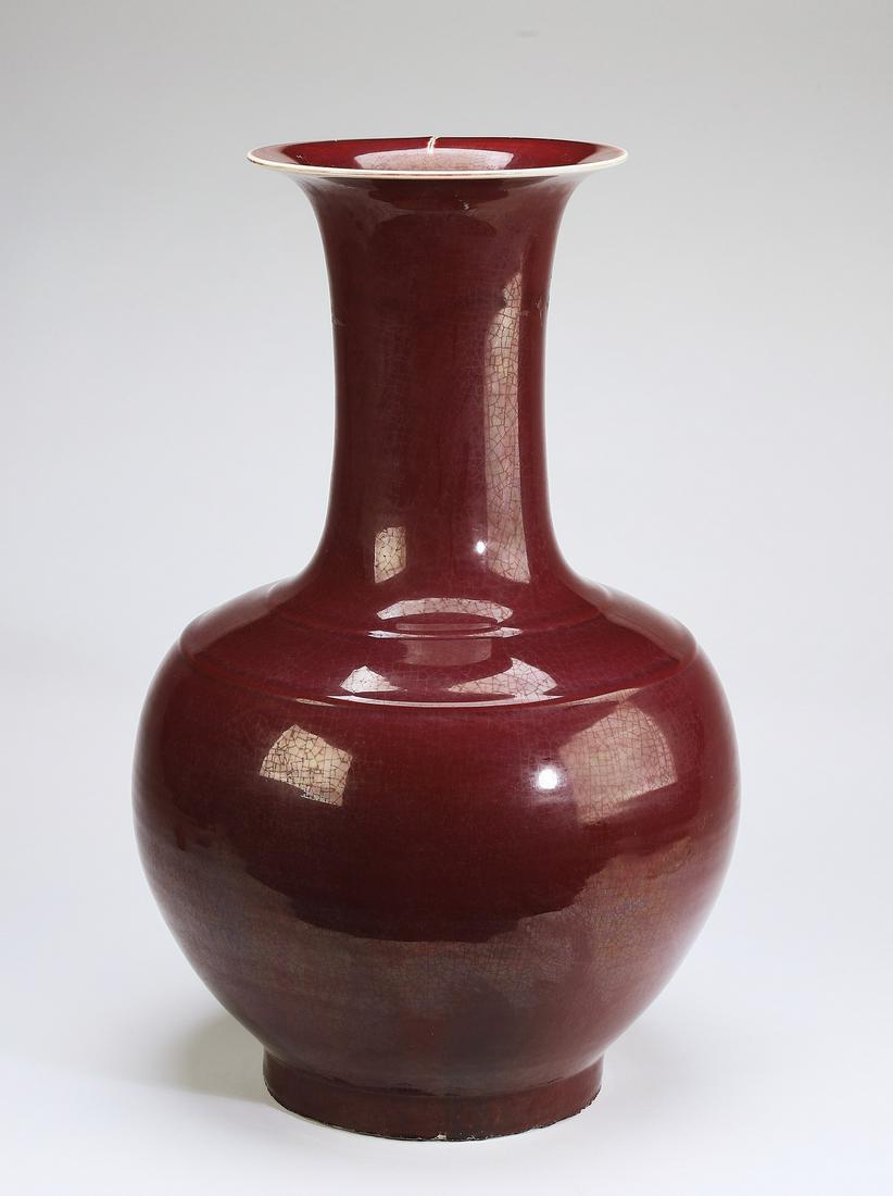Chinese sang de boeuf vase, Yongzheng mark: Chinese sang de boeuf bottle vase, having a trumpet neck above a bulbous body, the whole rising on a recessed circular foot, the underside with an impressed Yongzheng seal mark, 22"h x 11.5"w.