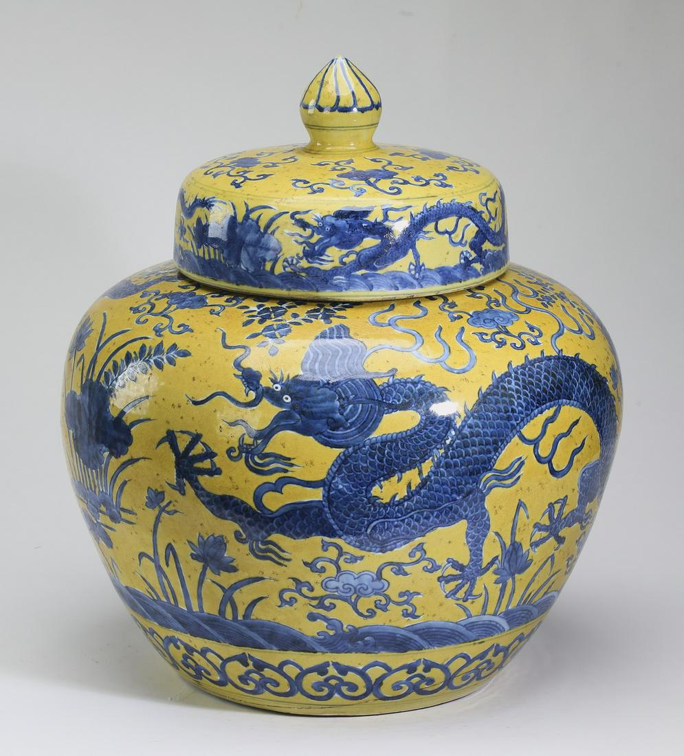 Chinese covered jar with dragons and lotus pond: Chinese famille jaune covered jar, the lid having a lotus bud finial above a shouldered body decorated throughout with writhing five clawed dragons in a lotus pond with pond weed and lingzhi, the whol