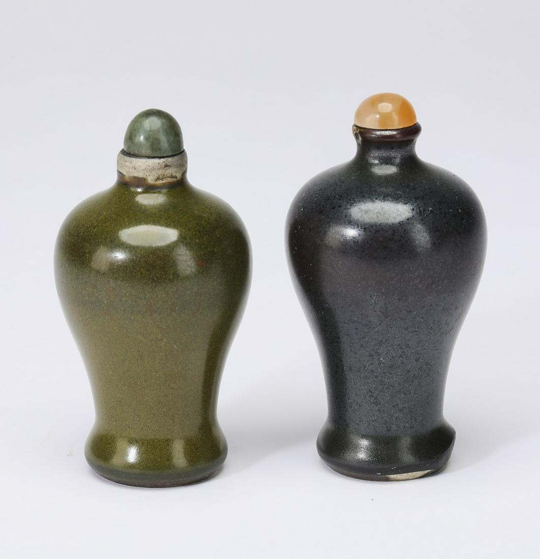 (2) Chinese porcelain snuff bottles w/ hardstone caps: Two Chinese monochromatic porcelain snuff bottles with later hardstone caps, both of meiping form, the first having teadust glaze and the second having black oil spot glaze, each tapering to a recesse