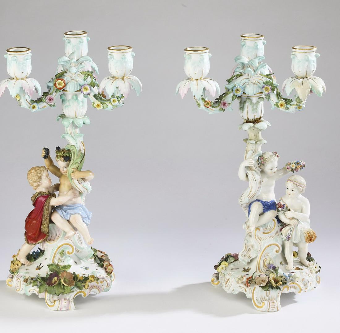 Pair of Meissen candelabra, maker marked: Near pair of Meissen candelabra in the Rococo taste, each having a sinuous standard terminating to a candle cup and issuing two sinuous arms with applied floral decoration also terminating to candle c