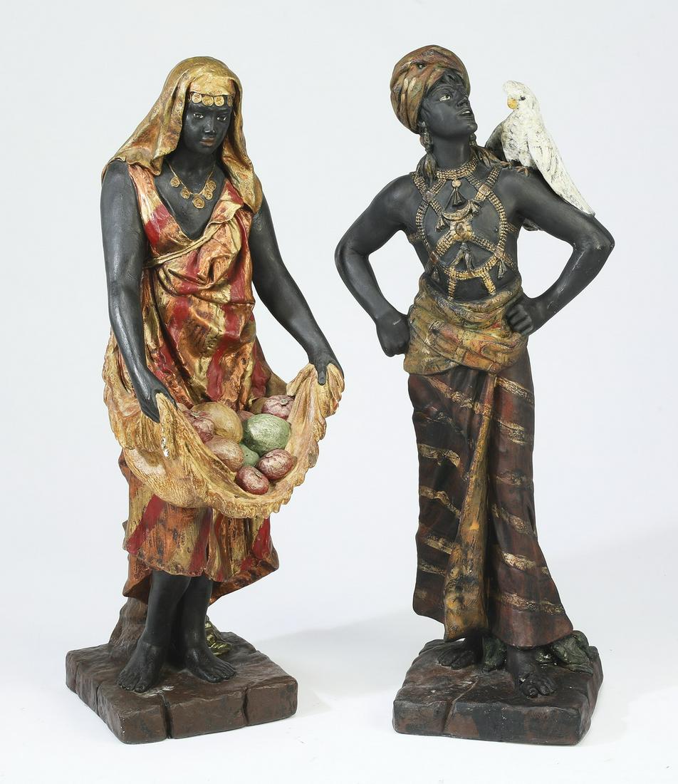 (2) Signed Josephine Mead blackamoor sculptures: Pair of Josephine Mead (American, 1919-200) blackamoor sculptures, 20th century, executed in paint-decorated terracotta, including a woman in gold garments carrying fruits, and a man wearing a turban 