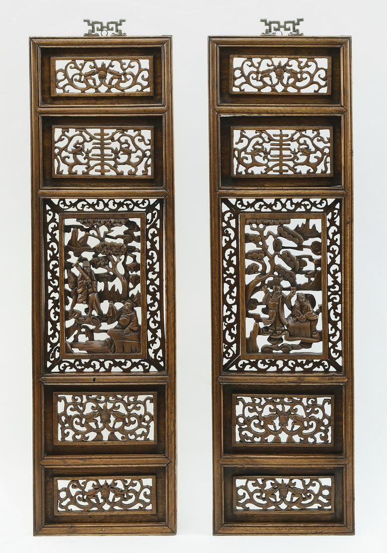 (2) Chinese carved hardwood panels w/ scholars: Pair of Chinese pierce carved hardwood panels, executed in five registers, each centering a depiction of scholars enjoying outdoor pursuits underneath parasol pine trees, flanked by Shou characters an