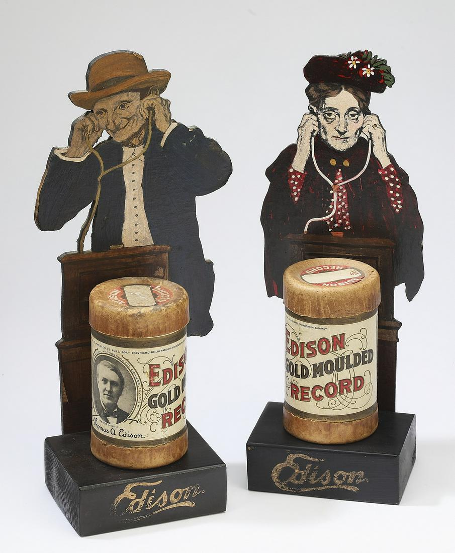(2) Edison Gold Moulded Record box displays: Pair of Edison Gold Moulded Record displays, 1904, each having an original box with the lid, presented on a paint-decorated wood stand depicting an elder listening to music, 12"h x 4.25"w x 3.25"d.