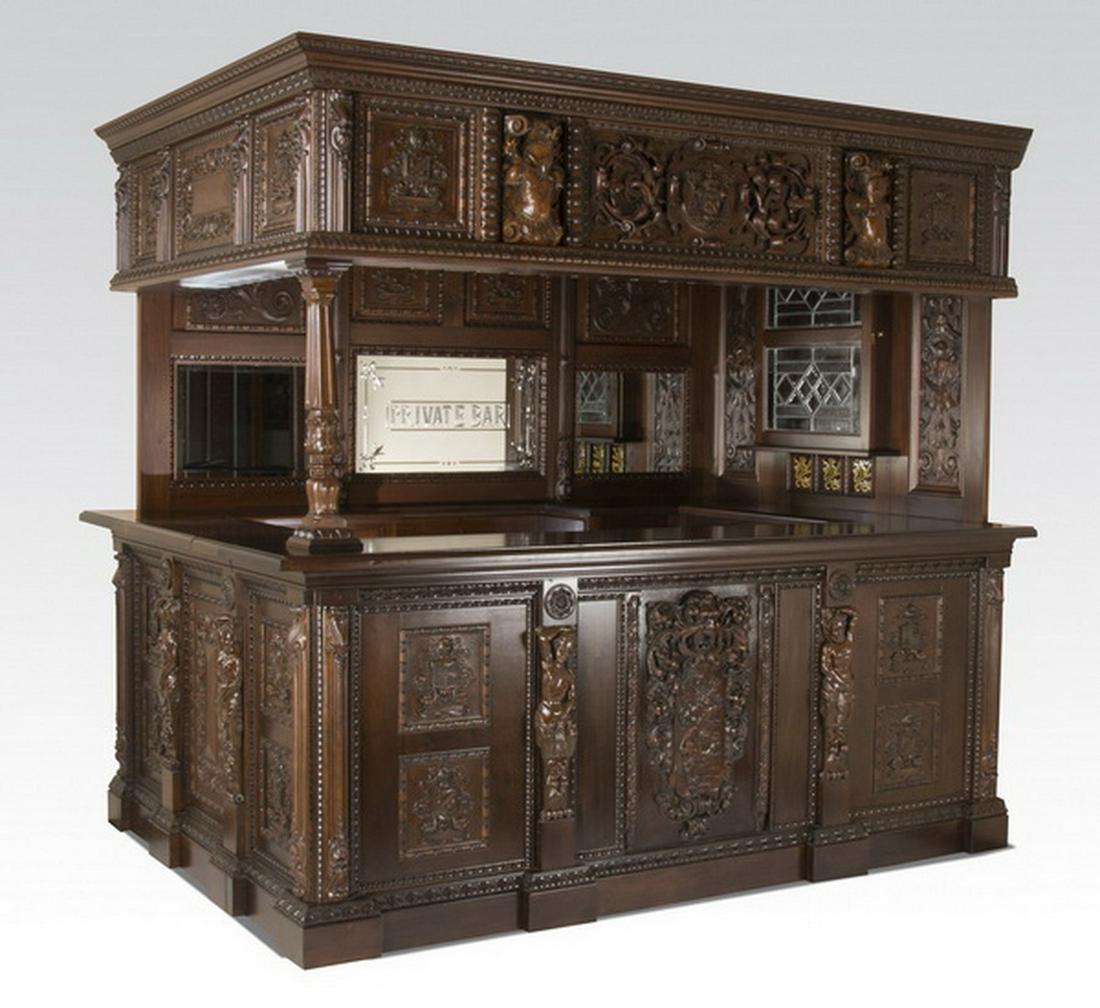Ornately carved corner pub bar w/ armorial plaques: Ornately carved walnut corner pub bar in the Renaissance Revival taste, having a stained glass paneled canopy surrounded by a carved cornice centering a high relief coat of arms flanked by armorial tr