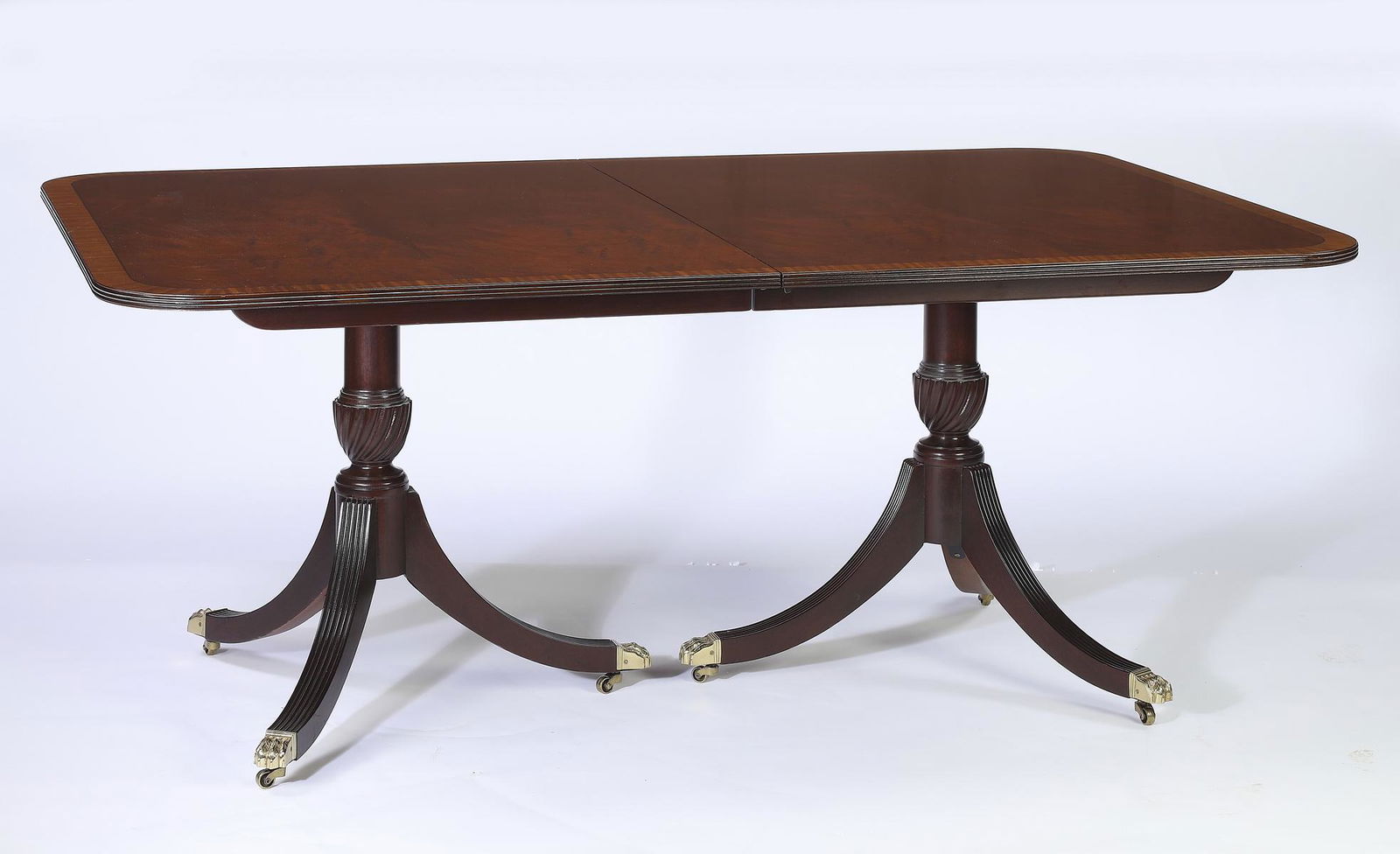 Queen Anne style mahogany dining table w/ 4 leaves: Queen Anne style double pedestal mahogany dining table, having an inlaid surface with rounded corners surmounting turned and spiral carved pedestals, each rising on four legs terminating in bronze paw