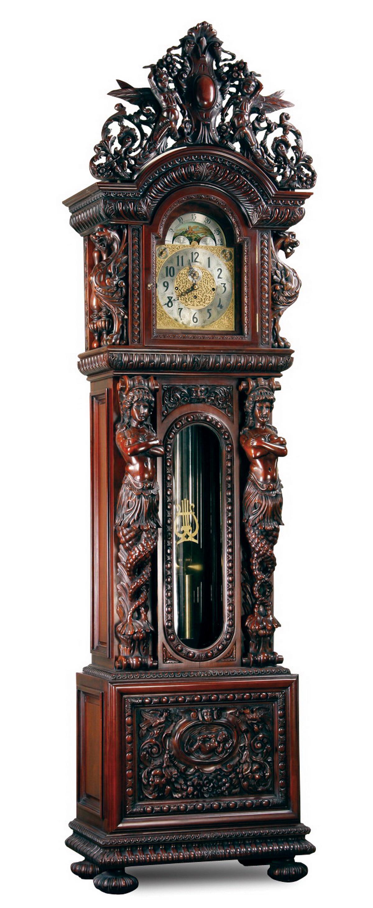 Carved mahogany Herschede clock, after R.J. Horner: Carved mahogany Renaissance Revival Herschede tall case clock, in the style of R.J. Horner, 20th century, having a pierce carved arched crest centering a cabochon flanked by angels and flowers, above 