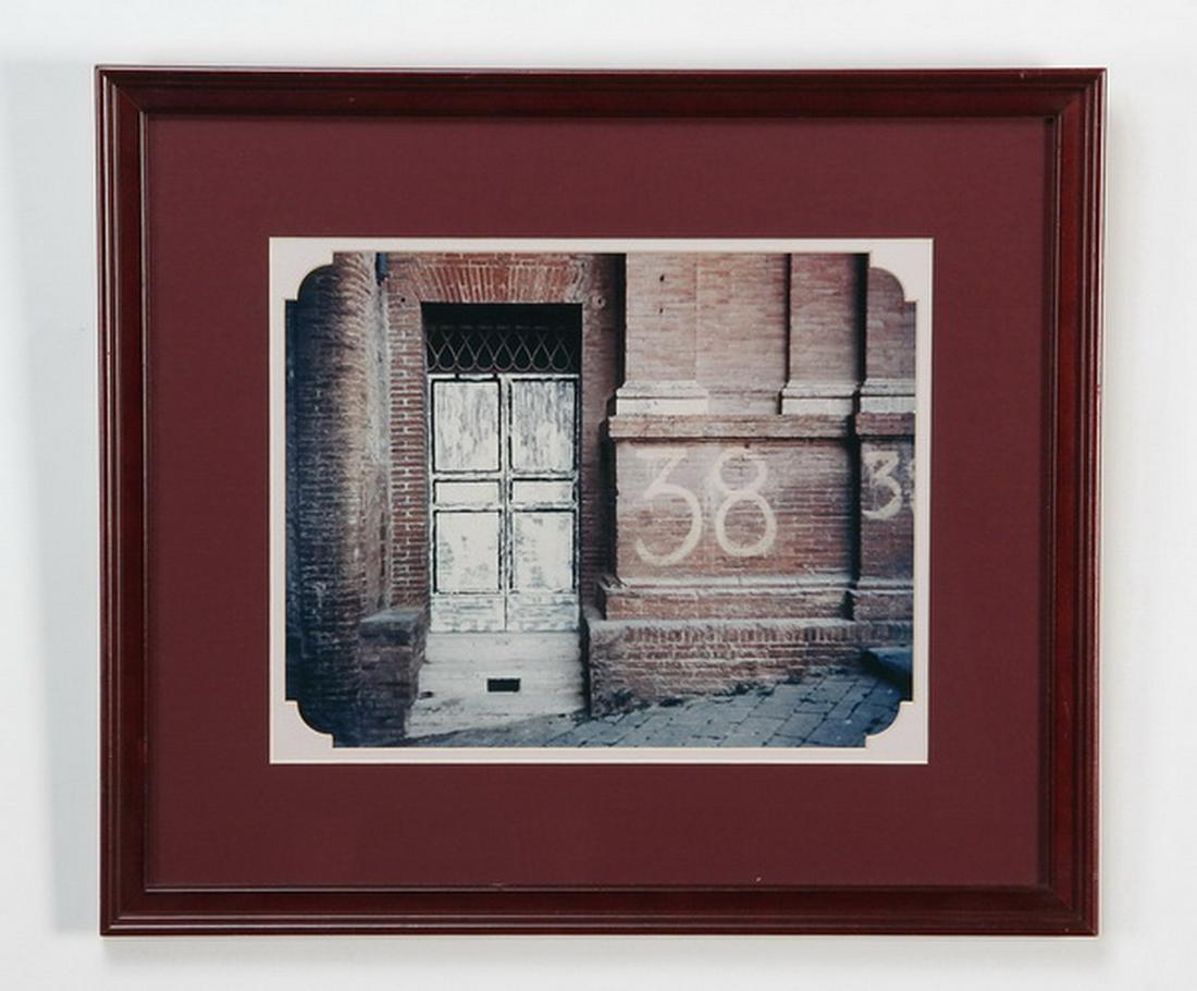 Framed and matted architectural photograph: Framed and matted color photograph of urban architecture, the brick building's exterior spray painted with the number 38, 11"h x 14"w, overall size including frame 18.5"h x 21"w x 1"d.