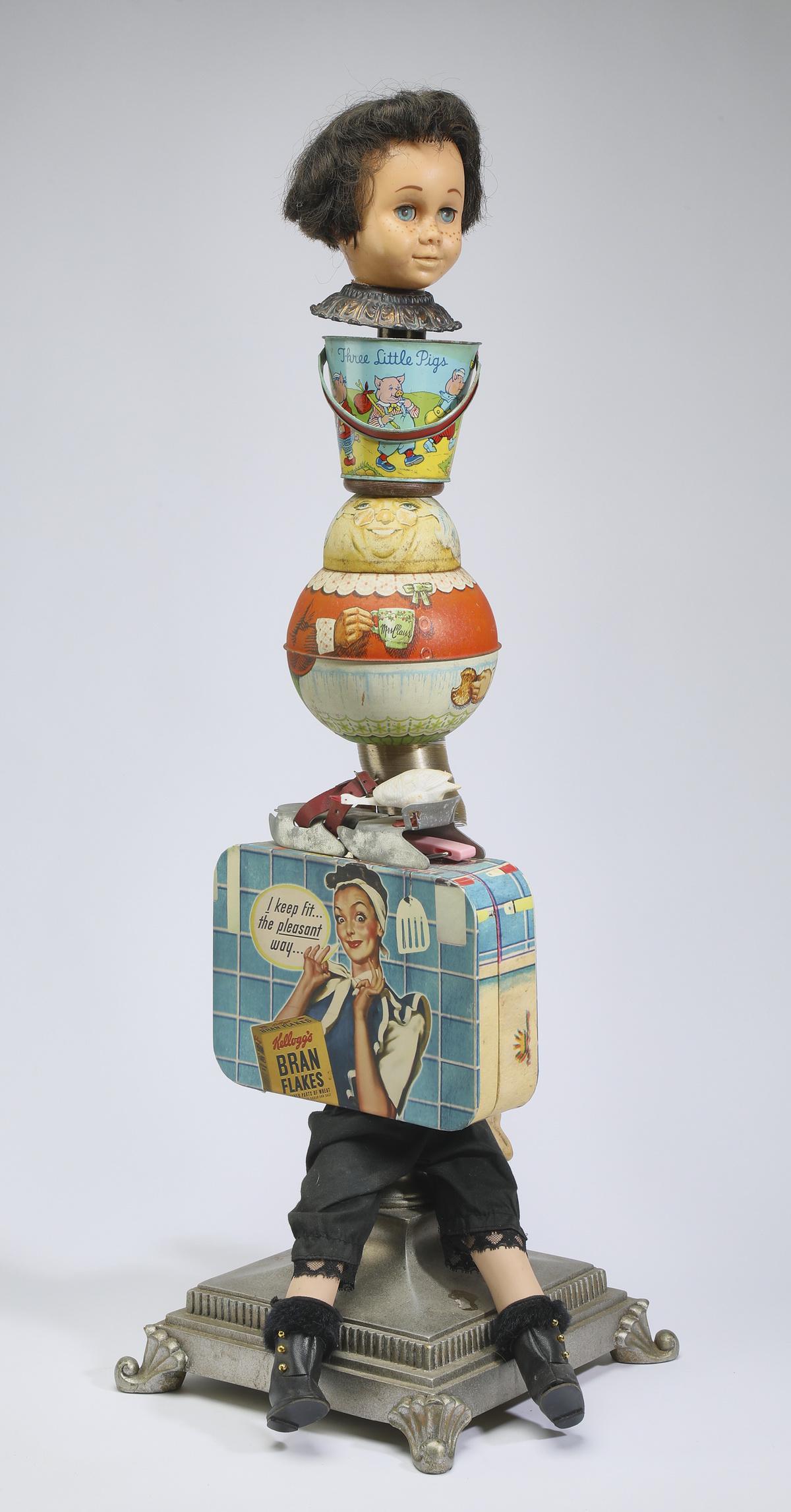 20th c. signed American mixed media sculpture, 34"h: American mixed media sculpture, 20th century, the assemblage comprised of found objects, including a baby doll, bucket, rolly polly, lunch box, and more, arranged in the style of a totem pole, signed