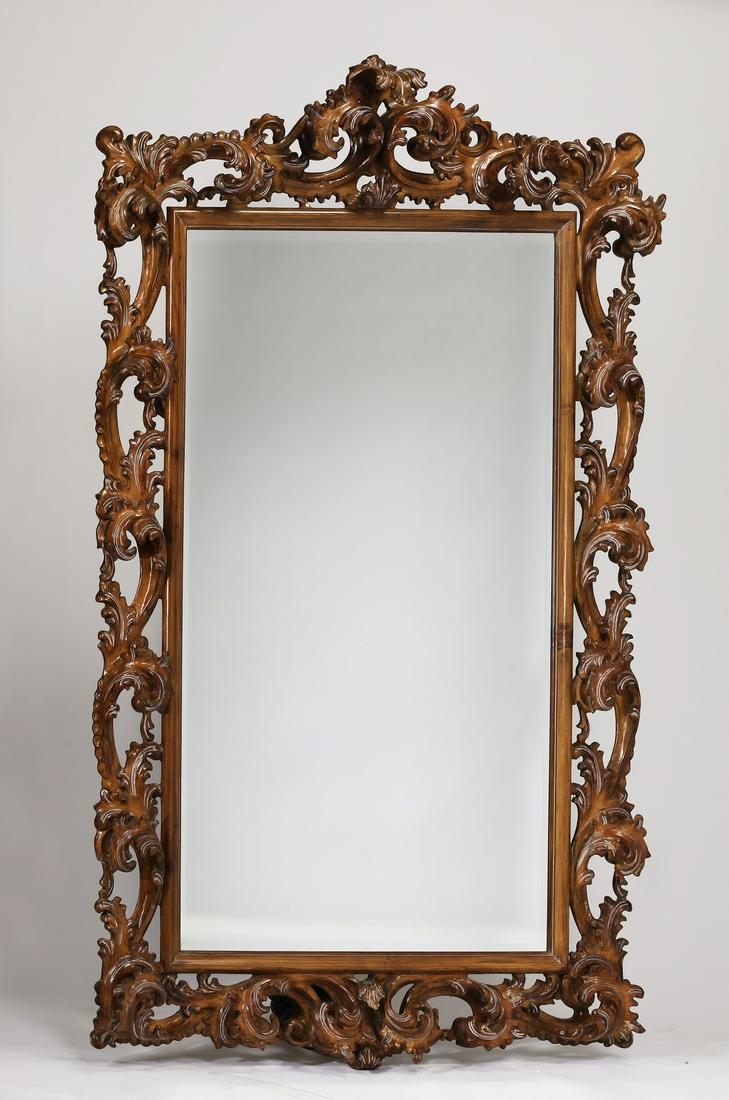 Monumental Rococo style carved wood mirror, 83"h: Monumental Rococo style carved wood mirror, having a forward arching acanthus leaf crest flanked by conforming pierced and carved scrolling leaves around the frame, the whole centering a rectangular b